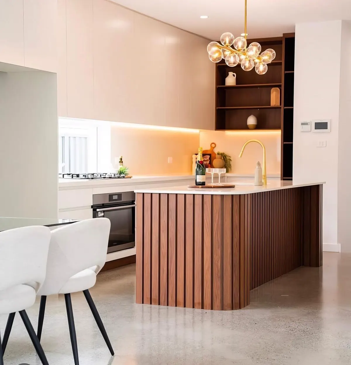 Kitchen renovation with fluted walnut island, brass tapware and stone benchtop