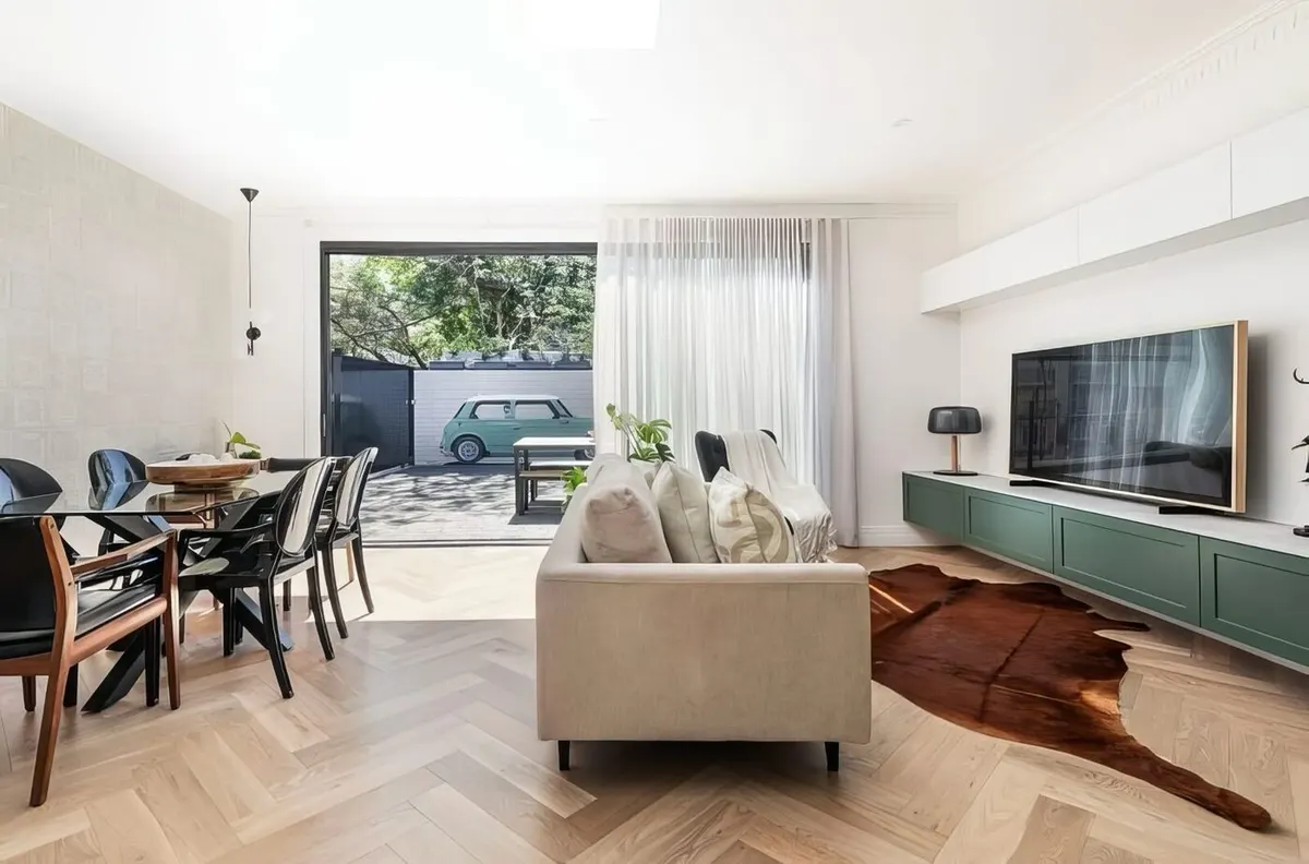 Open living and dining renovation with sage joinery, herringbone oak floors and garden access